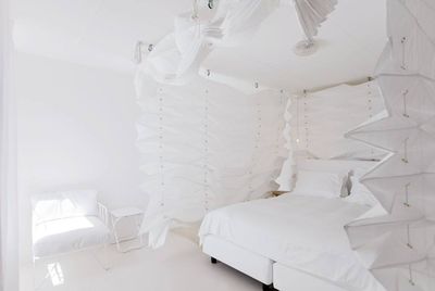 Witte kamer, bed met kraag eromheen in hotel The Exchange