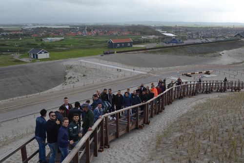 Studenten langs omheining op het strand voor International Week