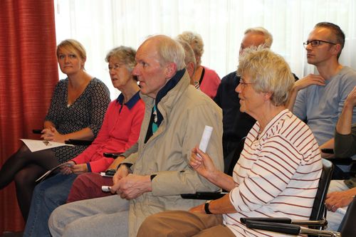 Meneer van den Heuvel kijkt tussen publiek naar het Magisch Interactief Schilderij