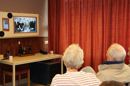 Mr van den Heuvel kijkt met zijn zus naar foto familie op de MIS