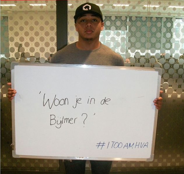 Student houdt bord omhoog met tekst: 'Woon je in de Bijlmer?' en hashtag #ItooamHvA