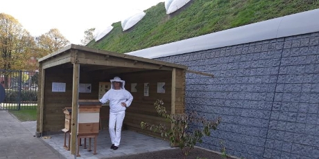 Imker bij het bijenhotel buiten de Sport en Foodcampus aan de Dr. Meurerlaan