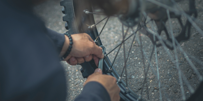 Afbeelding van twee handen die een fietsband repareren