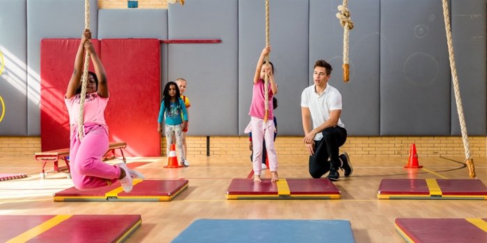 gymdocent in gymzaal met jonge kinderen