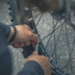 Afbeelding van twee handen die een fietsband repareren