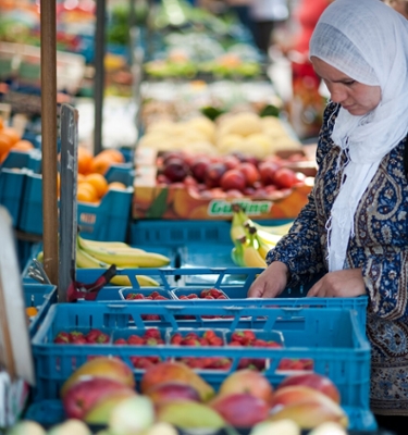 vrouw bij marktkraam groenten en fruit